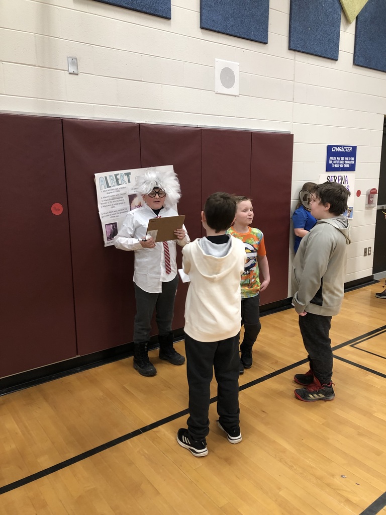 students dressed up as historical figures with other students standing and listening to them talk