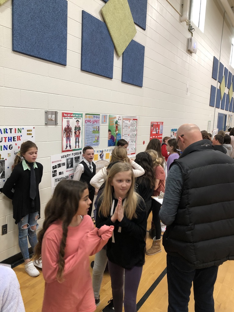 students dressed up as historical figures with other students standing and listening to them talk