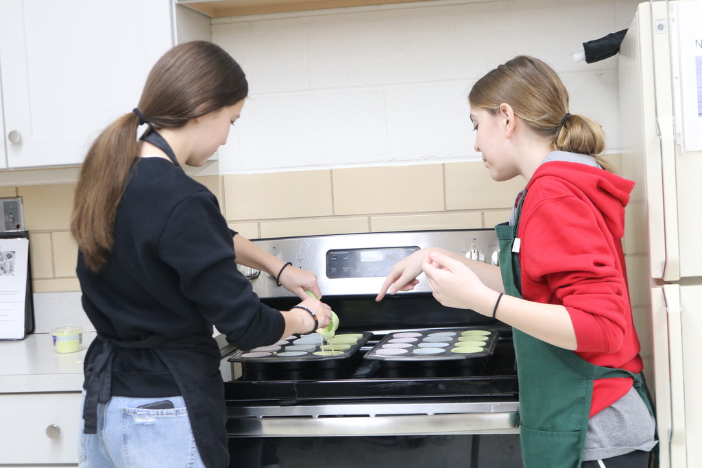 Students adding batter to cupcake tins.