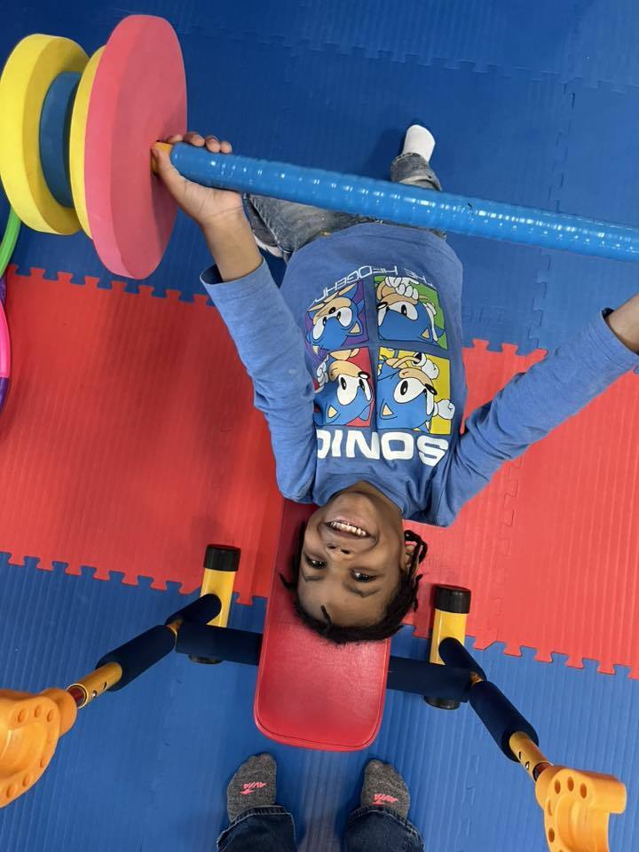 young boy lifting children weights.
