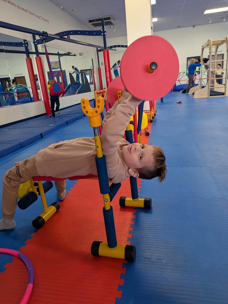 young boy lifting children weights.