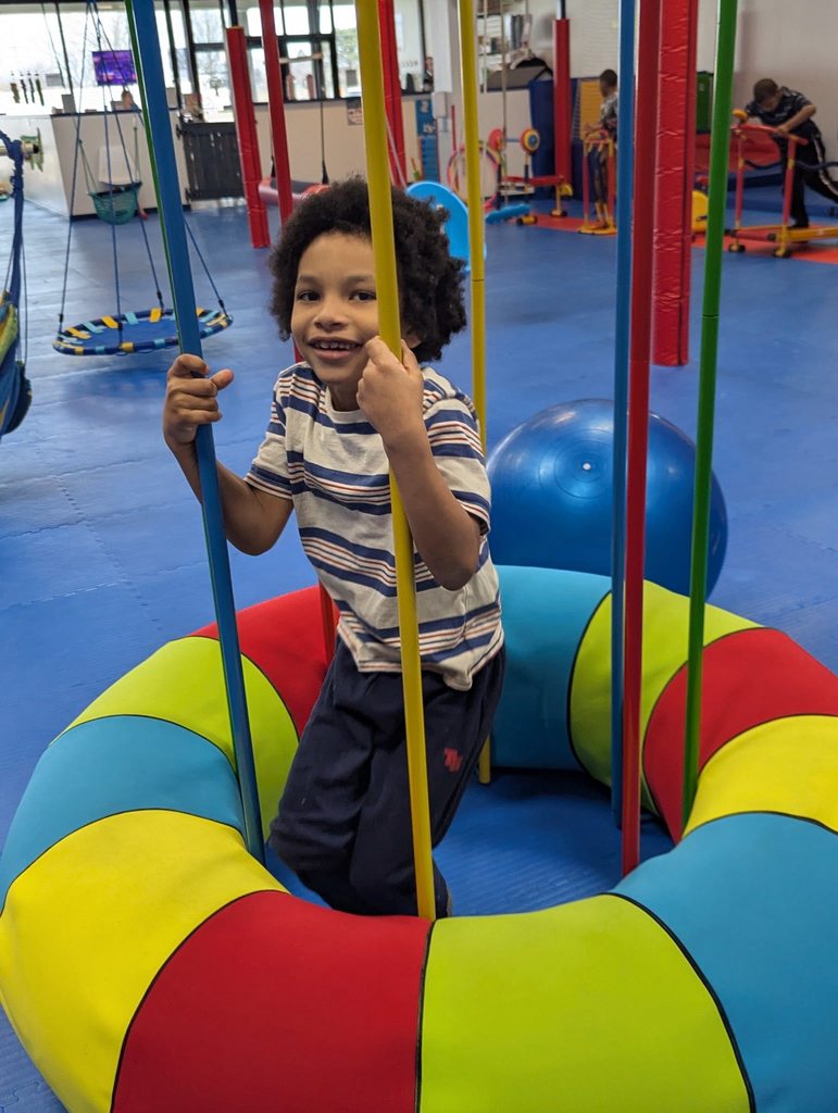 Young boy on a circular swing.