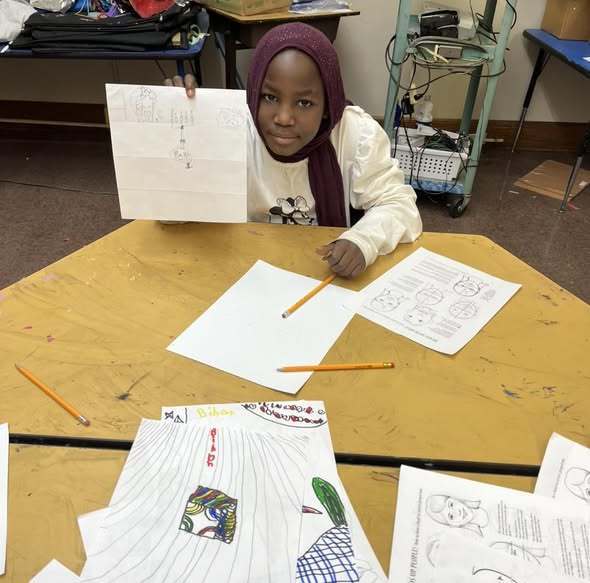 Students showing her drawing.