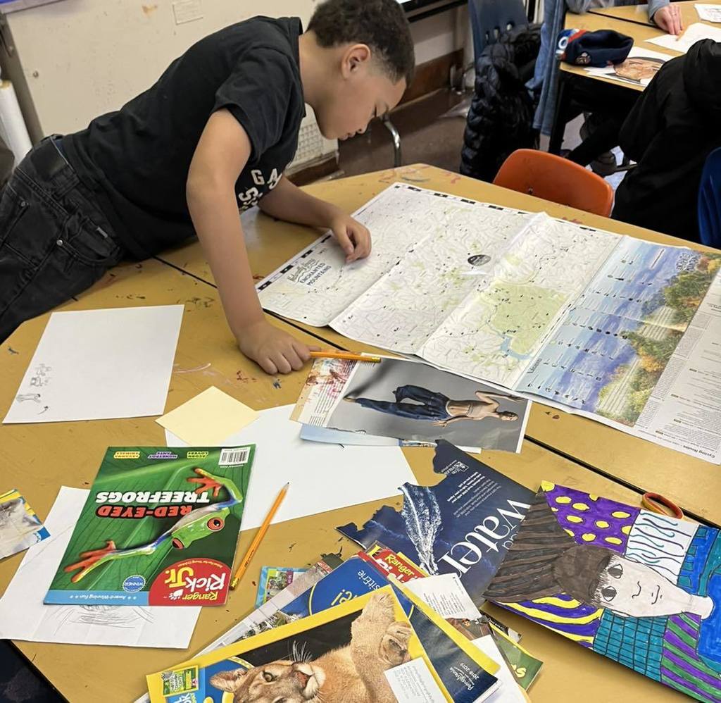 Student leaning on his school desk looking at a map. 