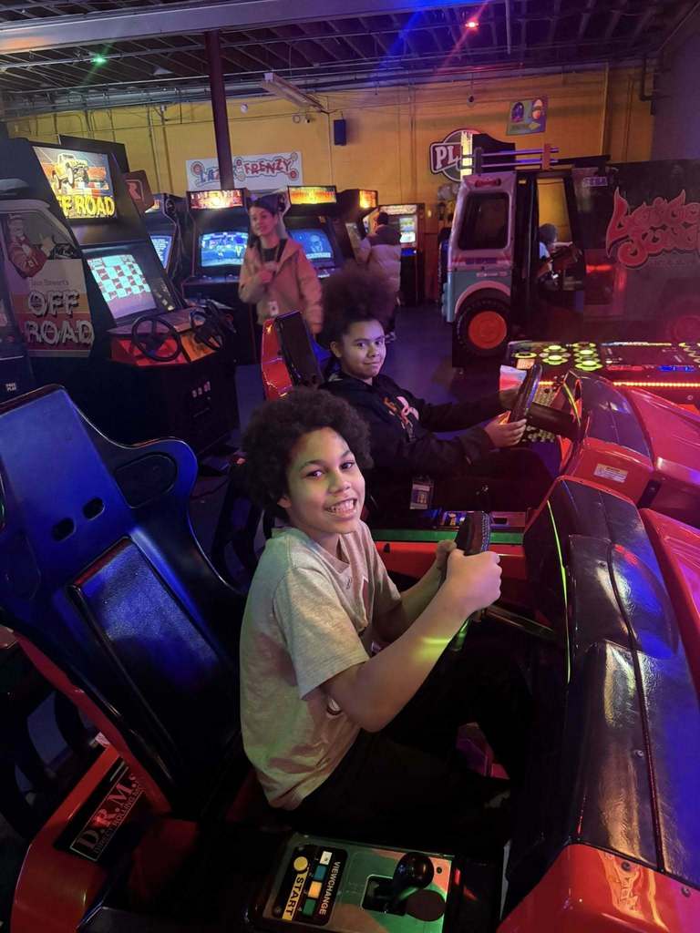 Kids racing at an arcade game. 