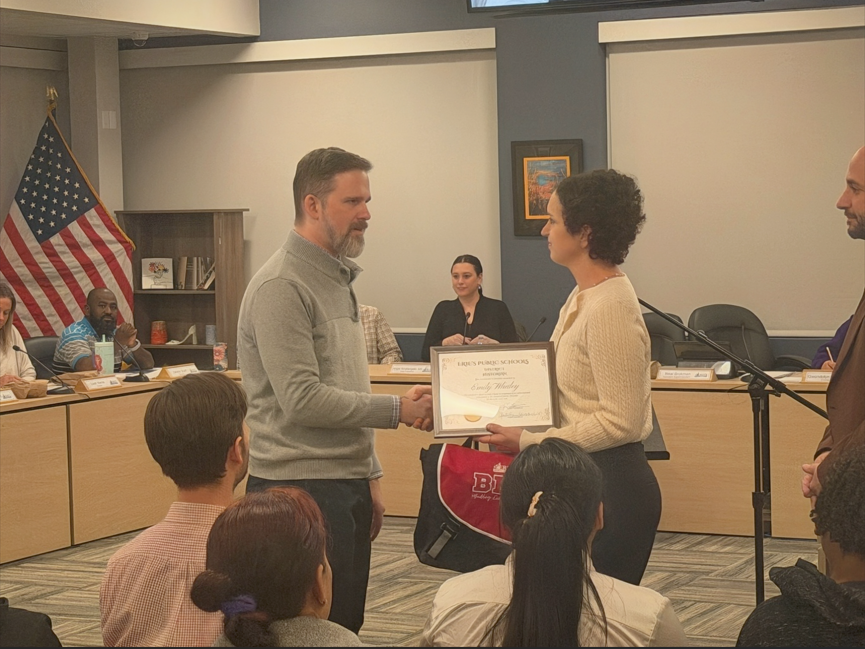 women recieving a certificate and shaking a mans hand.