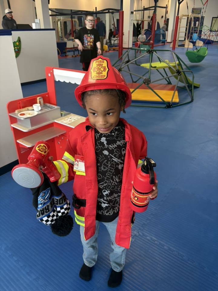 Young boy dressed as a fire fighter.