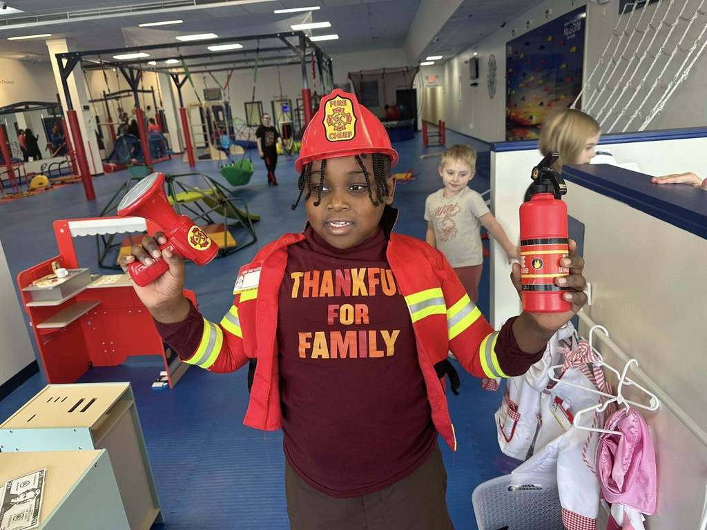 Young boy dressed as a fire fighter.
