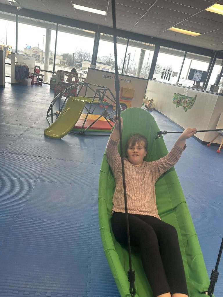 Young chilld in a green hammock swing.