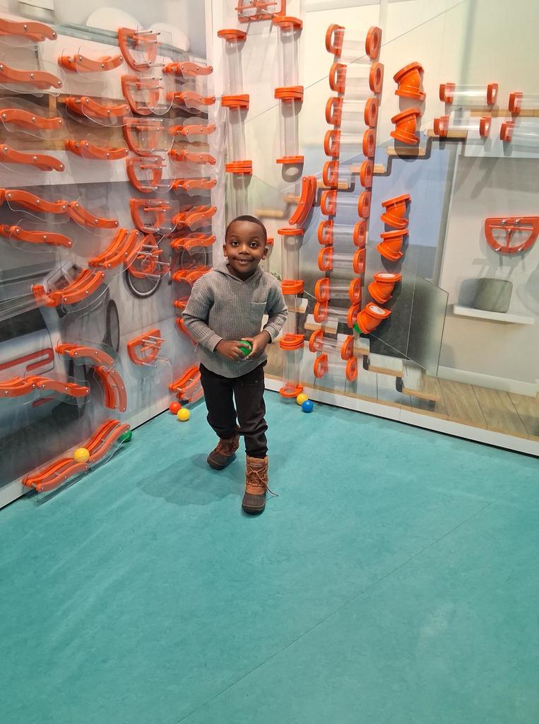 Young boy in a gray hoodie smiling.