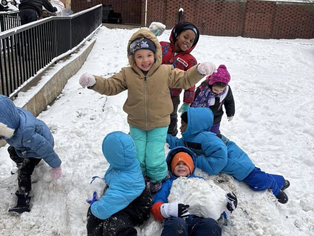 Kids playing in the snow and smiling. 