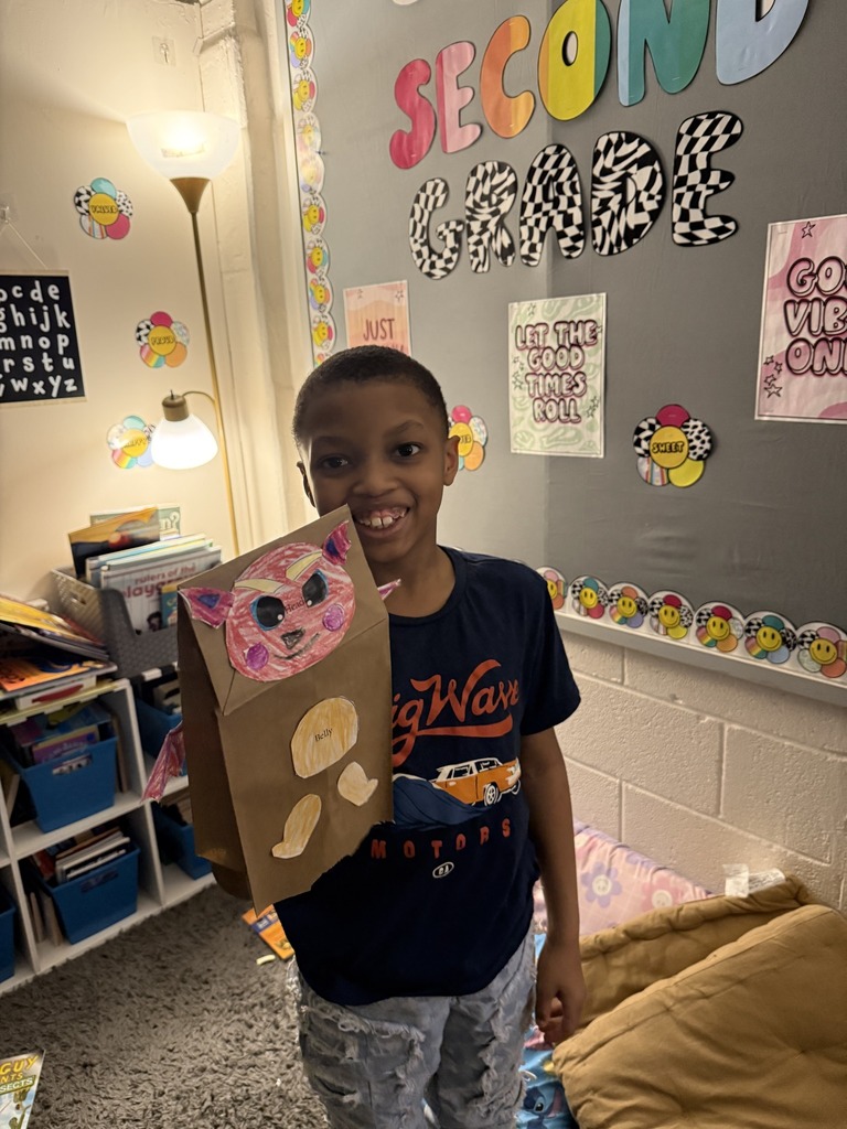 Young boy holding his dragon puppet up.