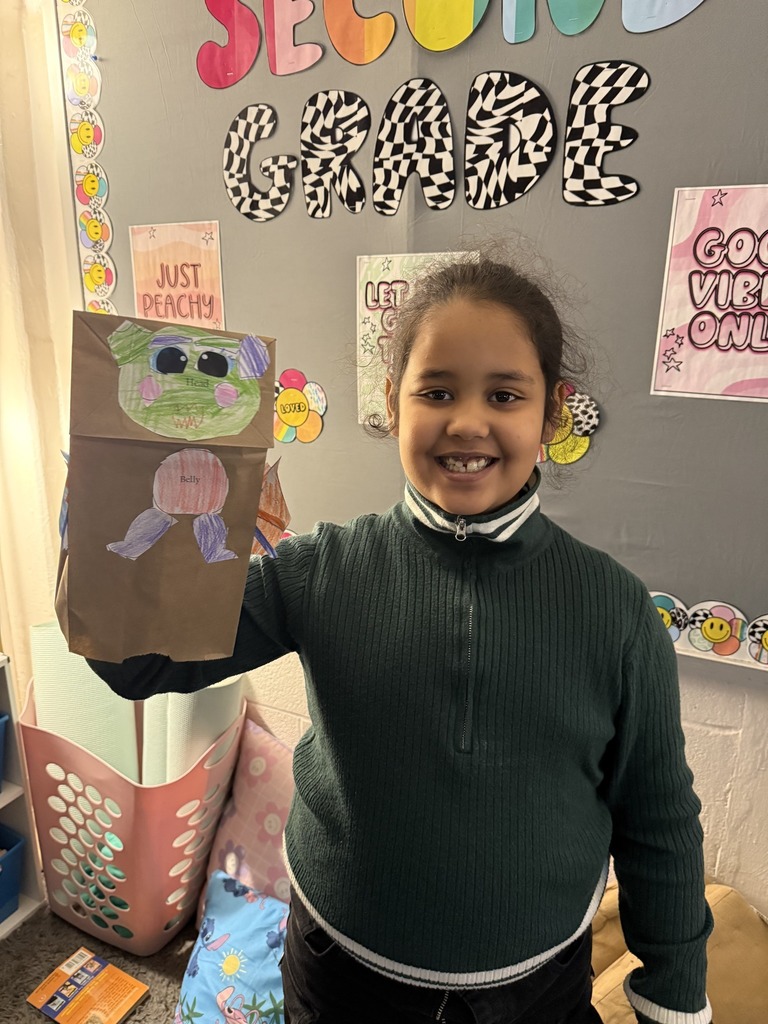 Young girl holding his dragon puppet up.