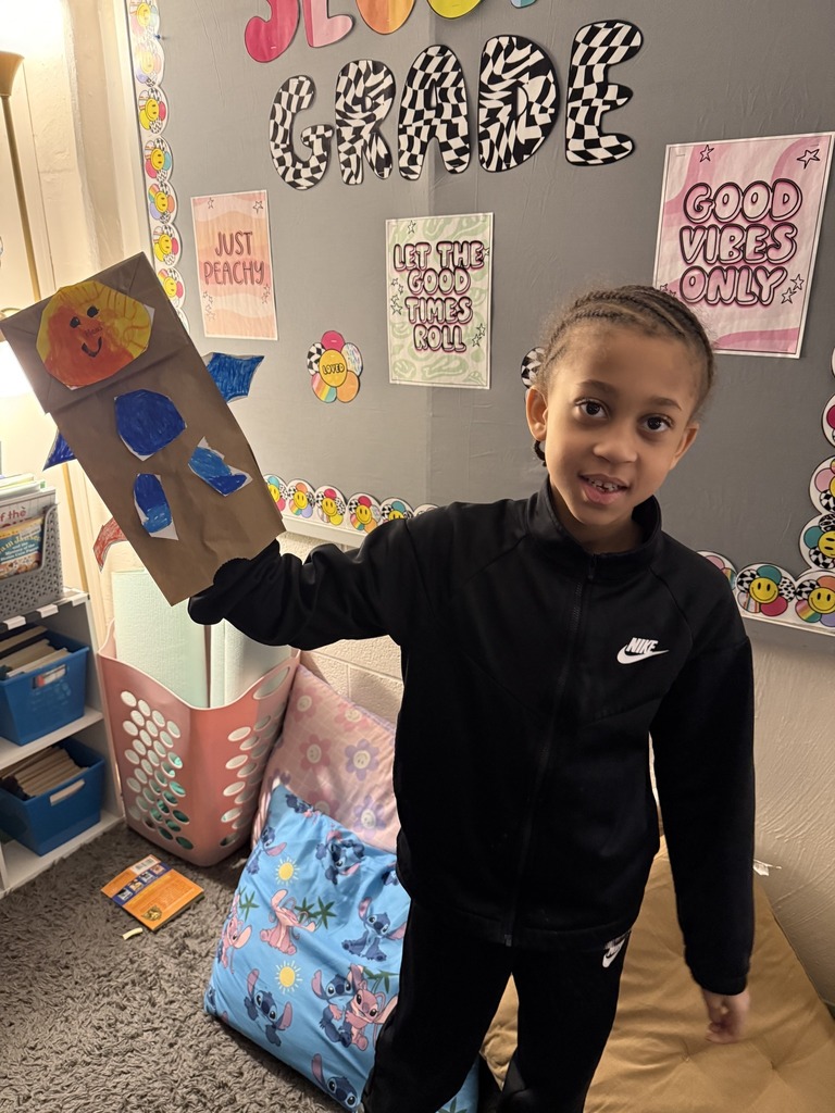 Young boy holding his dragon puppet up.
