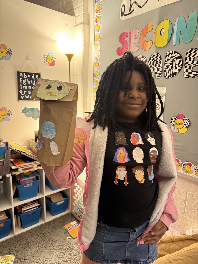 Young child holding his dragon puppet up.