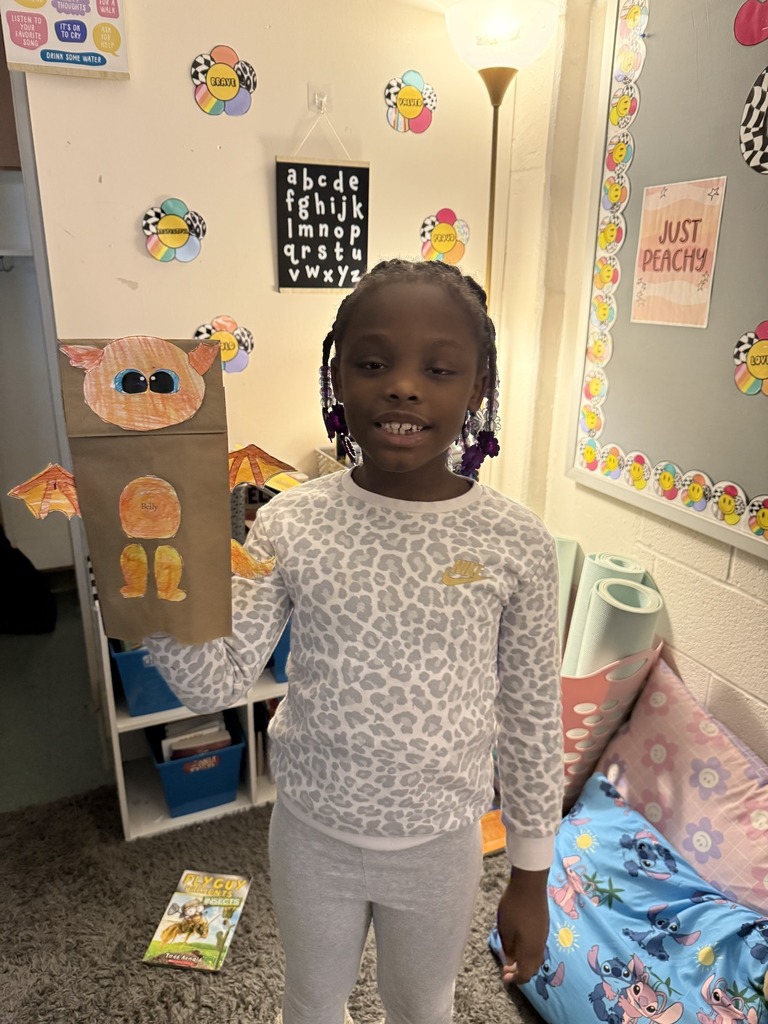 Young girl holding his dragon puppet up.