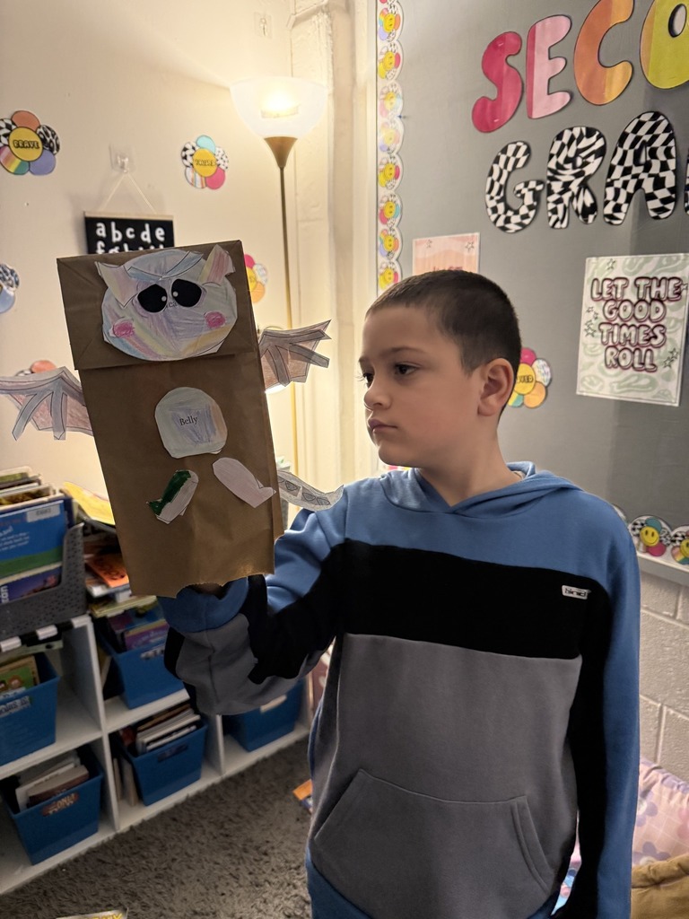 Young boy holding his dragon puppet up.