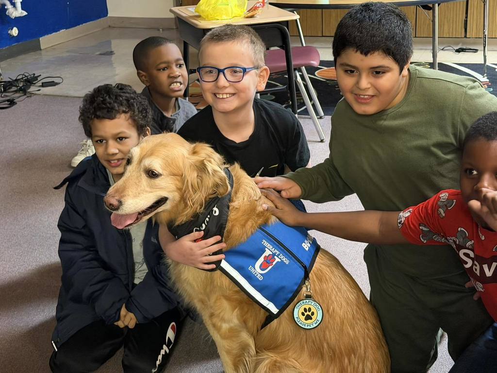 Kids posing and smiling with a golden retriever dog. 