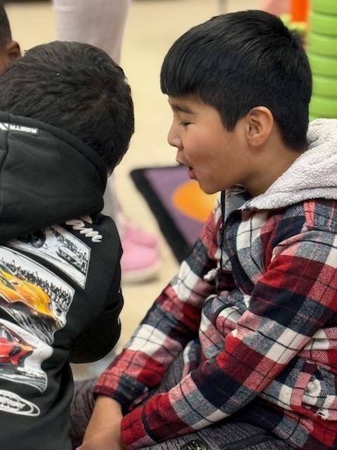 Kid smiling in a red and black flannel.