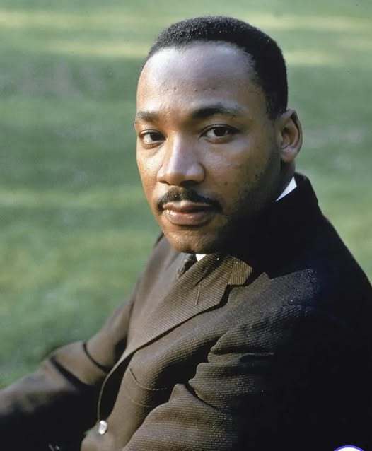 Martin Luther King, Jr. in a black suite outside. 