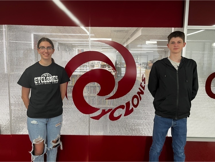 two students standing by a cyclone 