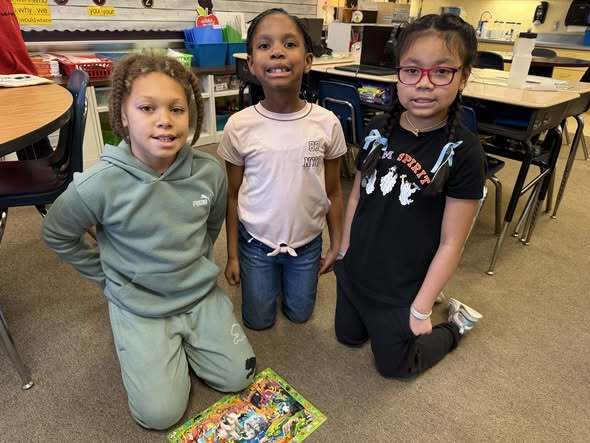 Kids smiling in a classroom. 