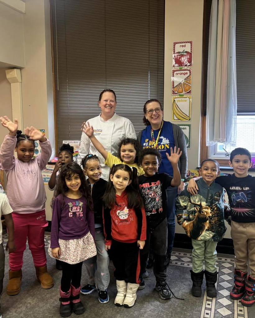 A group photo of kids, and adults in a classroom 