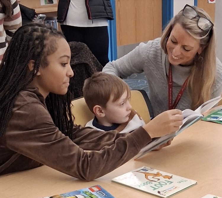 Ernie Davis Academy students reading to primary aged students 