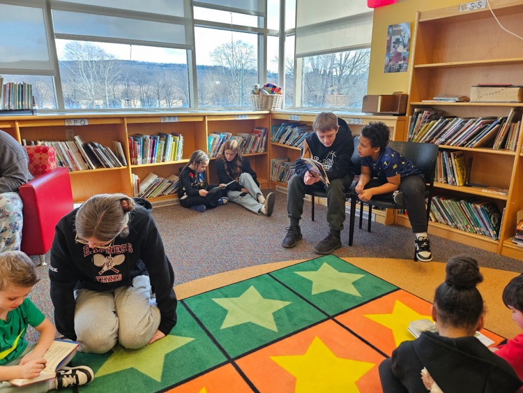 Ernie Davis Academy students reading to primary aged students
