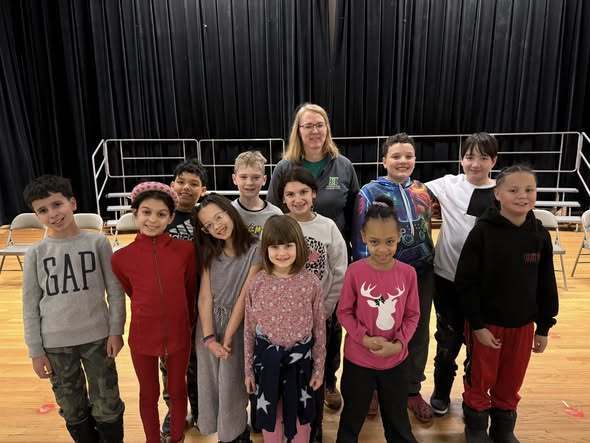 Students and teacher smiling.