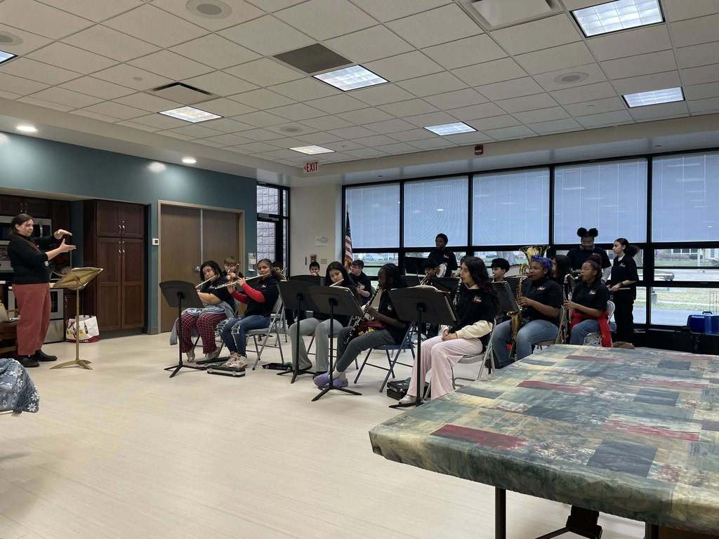 Kids playing instraments in a large room.