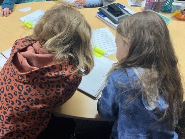 Two students editing their work. 