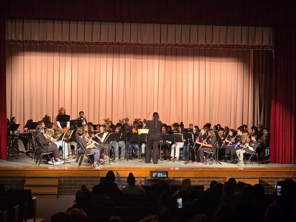 Kids playing instruments at a concert on stage. 