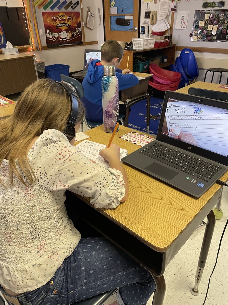 A student looks at a screen holding a pencil.