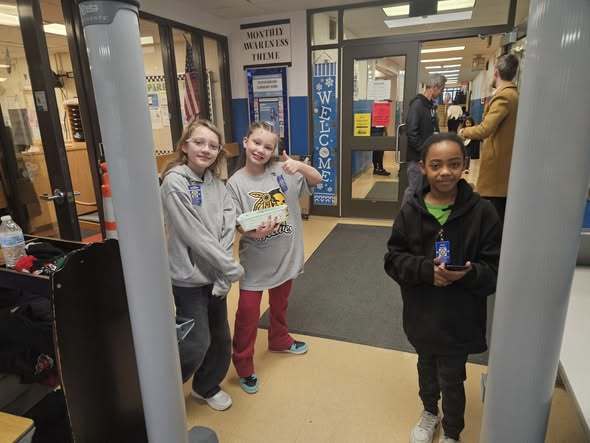 Young girls standing in the hall and smiling.