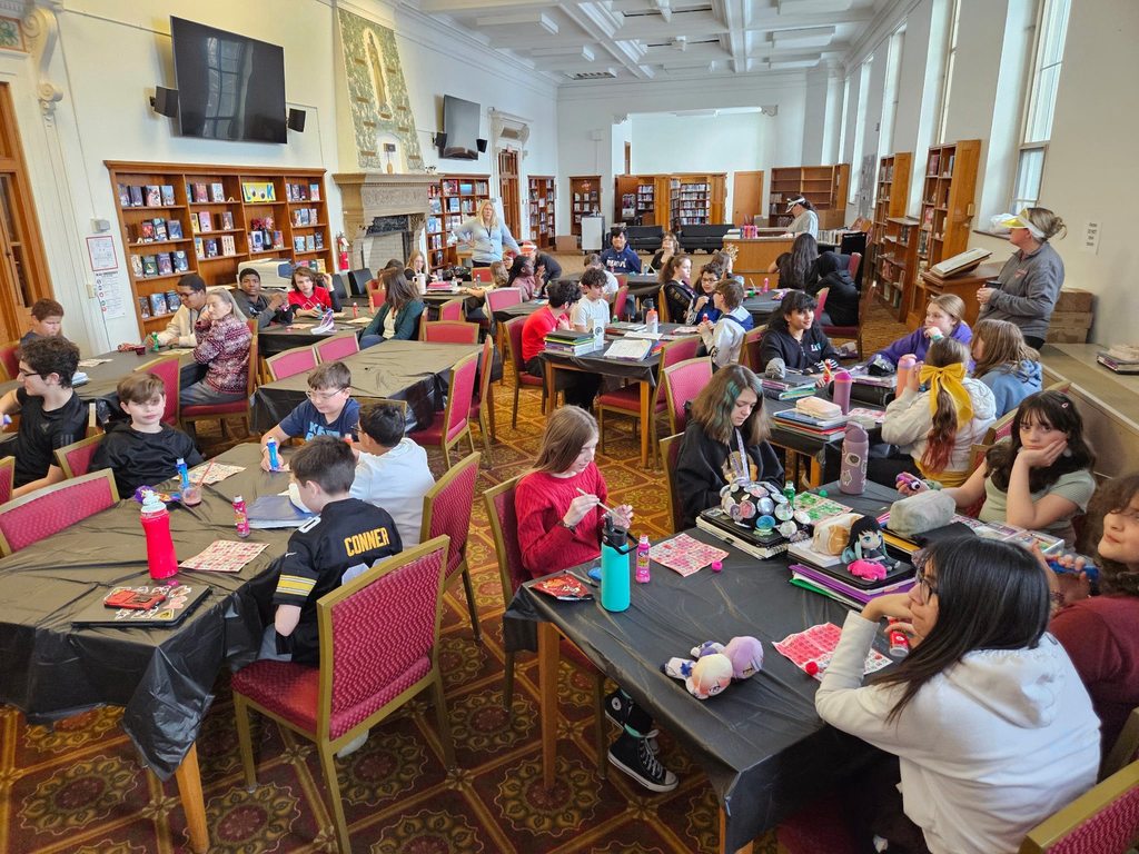 Kids at tables playing games and making art.
