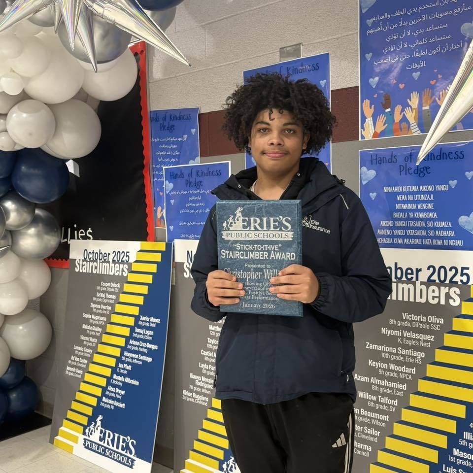 Young boy holding his award. 