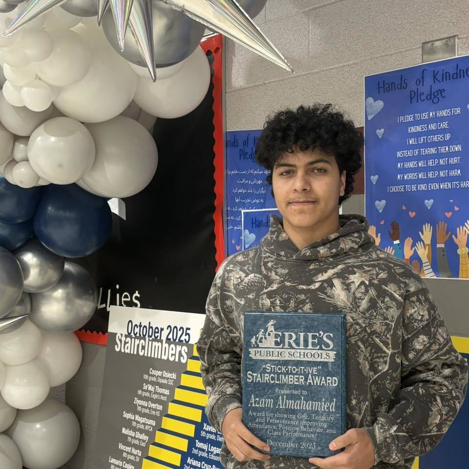Young boy holding his award. 