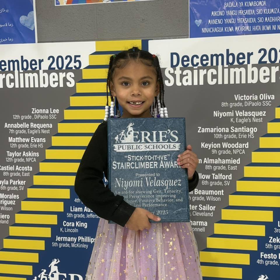 Young girl holding her award. 