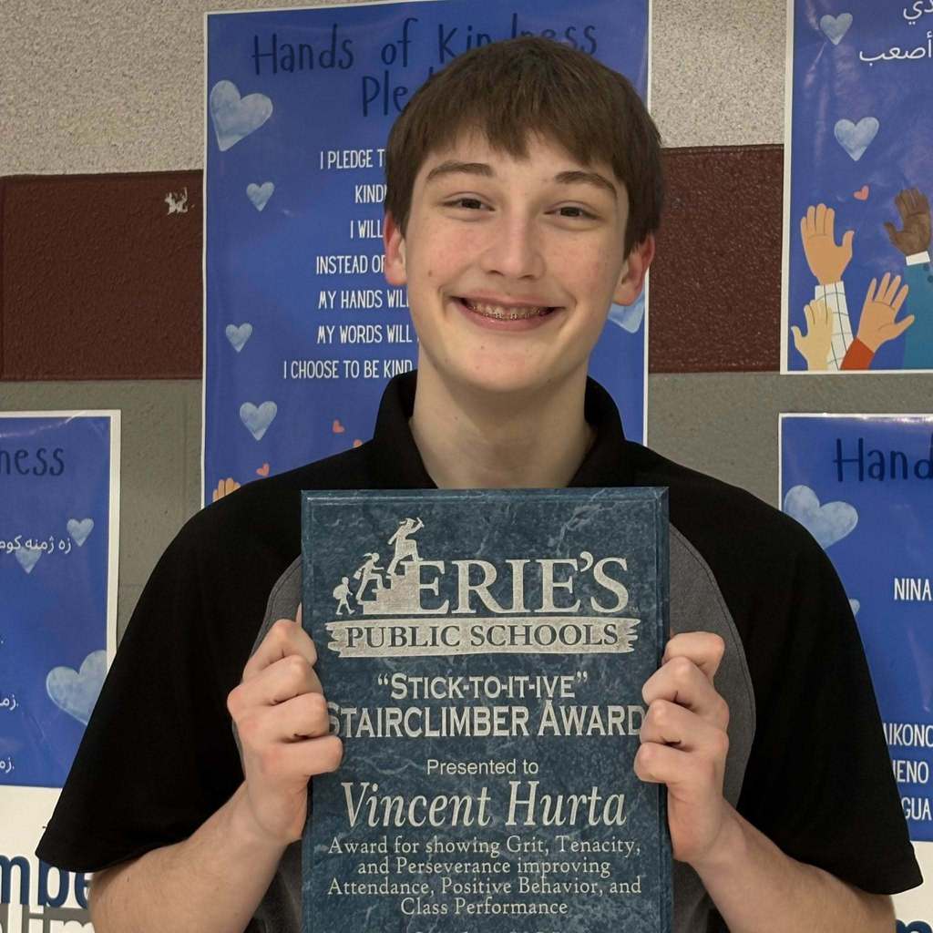 Young boy holding his award. 