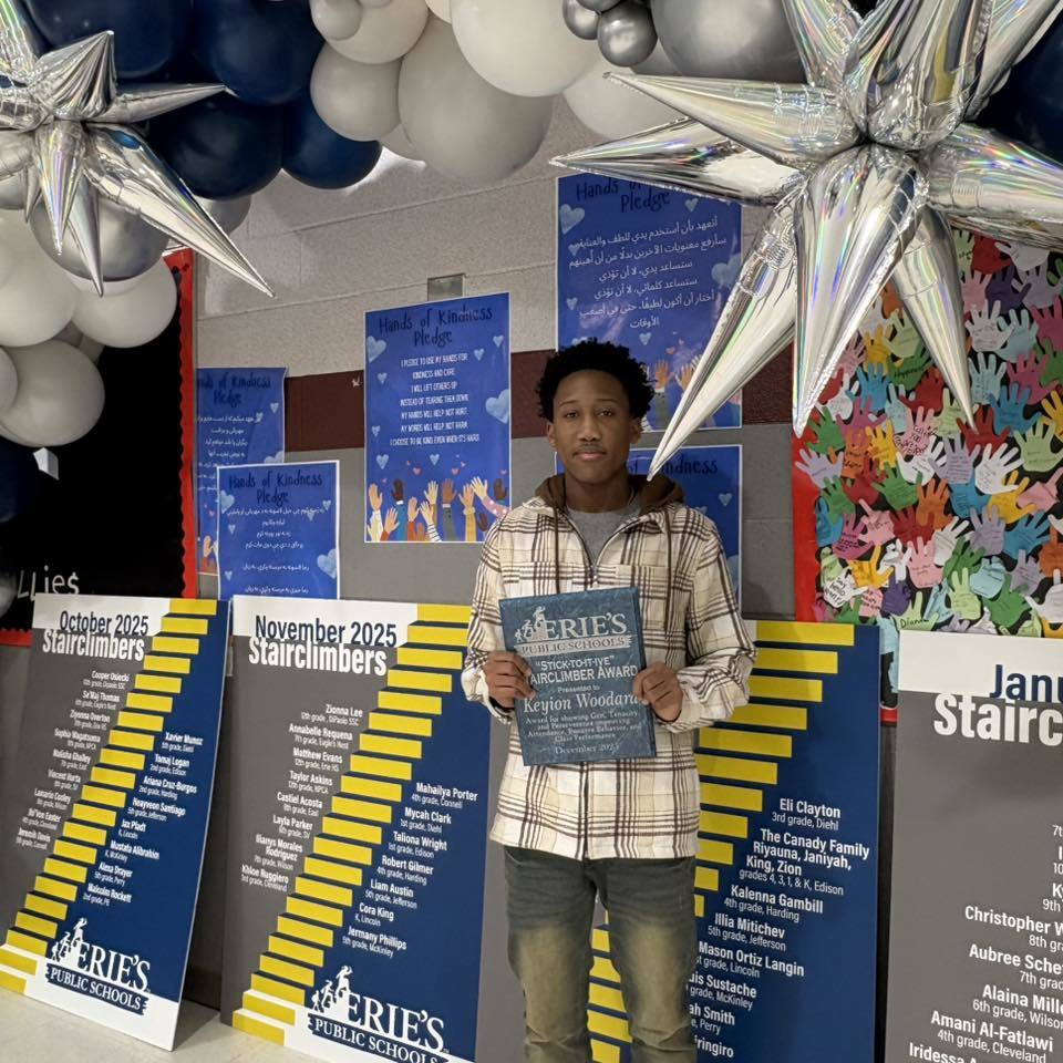 Young boy holding his award. 