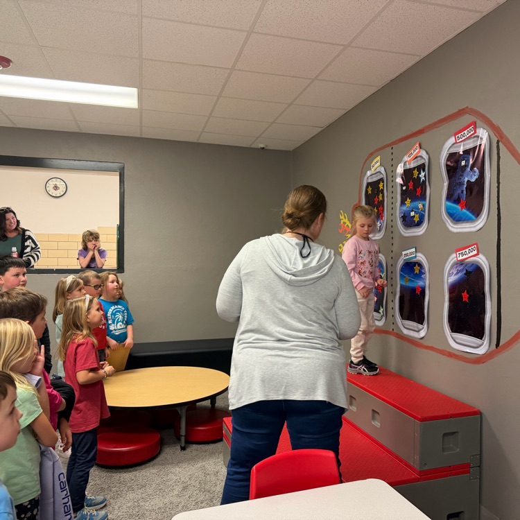 Student placing her star on the rocket ship