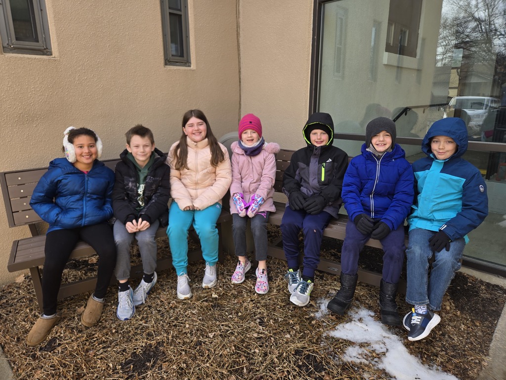 Seven 3rd graders on the benches outside