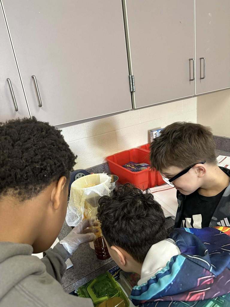 Kids in a classroom doing a experiment. 