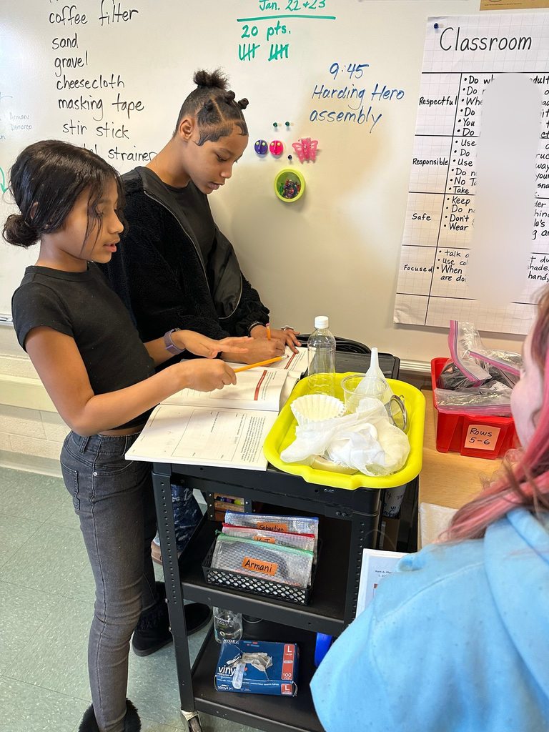 Kids in a classroom doing a experiment. 