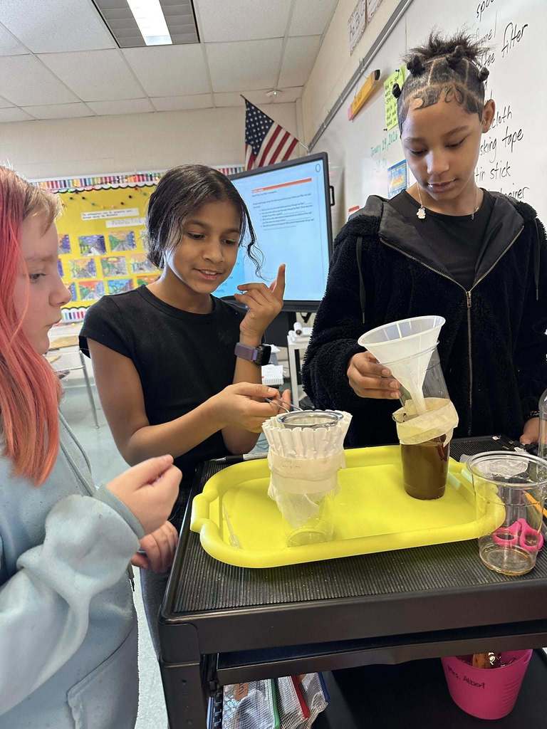 Kids in a classroom doing a experiment. 