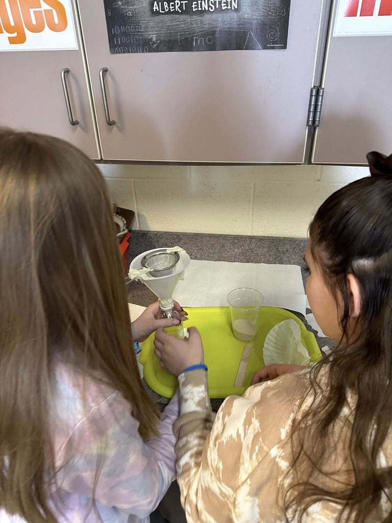 Kids in a classroom doing a experiment. 