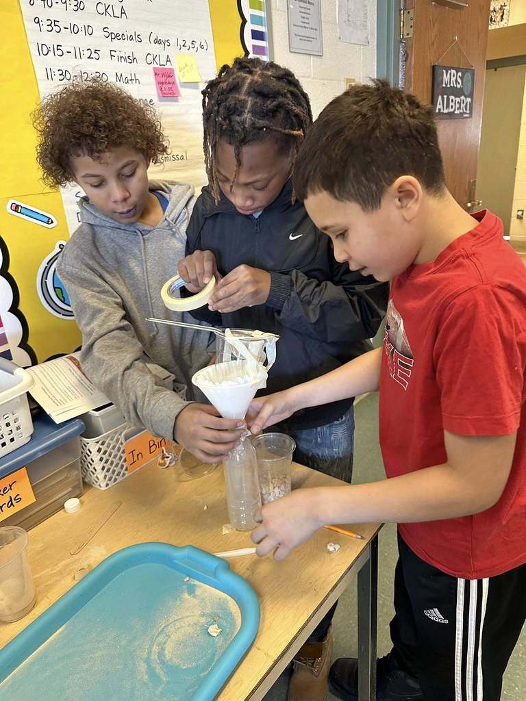 Kids in a classroom doing a experiment. 