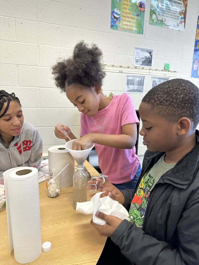 Kids in a classroom doing a experiment. 