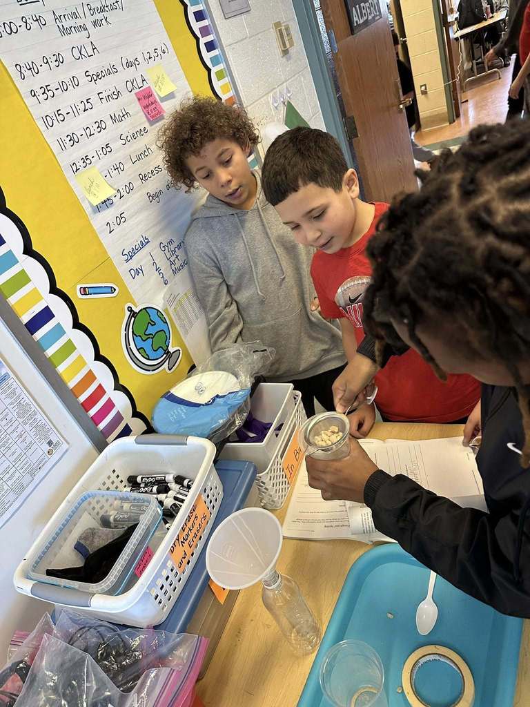 Kids in a classroom doing a experiment. 